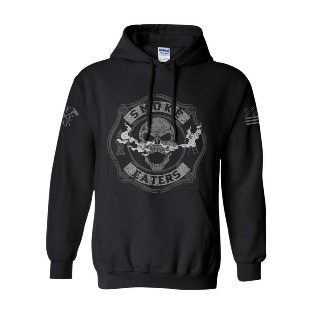 Front view of firefighter hoodies in black color featuring a full-front design print of a skull inhaling smoke, with a distressed grey and off-white look.