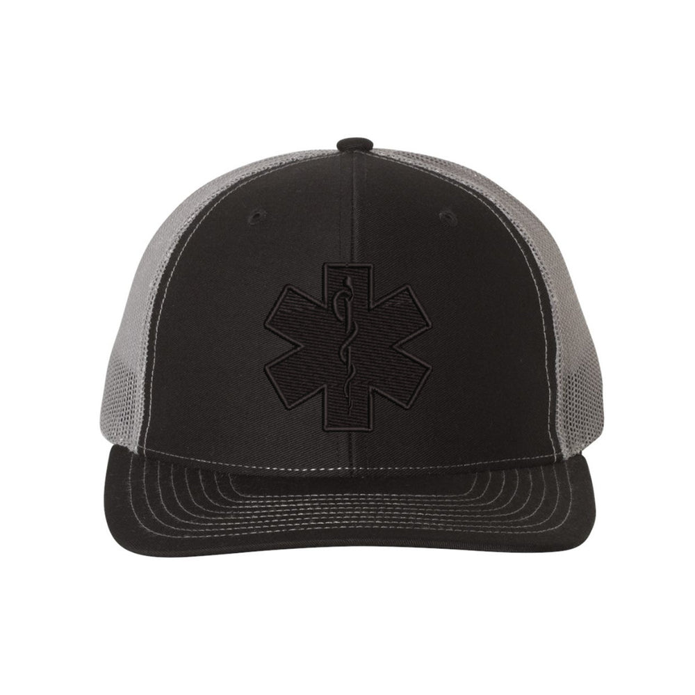 Blackout snapback trucker hat featuring the Star of Life emblem in black embroidery.