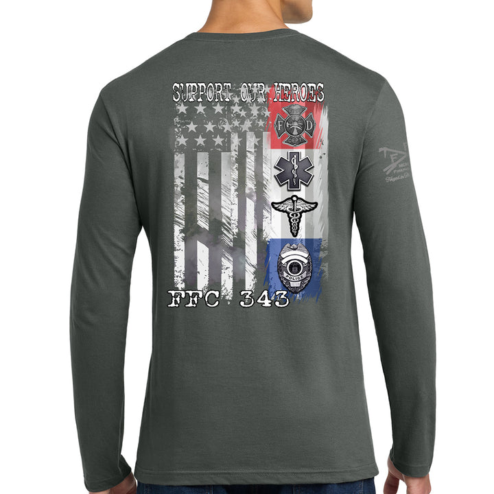 A man wearing a dark gray long-sleeve t-shirt, viewed from the back. The shirt features a large graphic print on the back with a distressed American flag, military-style badges, and the text 'SUPPORT OUR HEROES' and 'FFC 343'. #color_charcoal