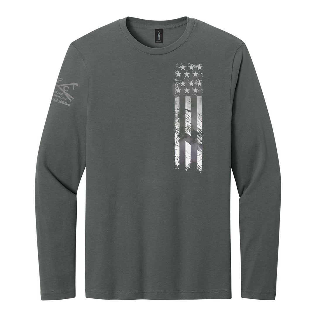 A dark gray long-sleeve t-shirt with a distressed vertical American flag graphic on the left chest and a subtle logo on the right sleeve, shown on a plain white background. #color_charcoal