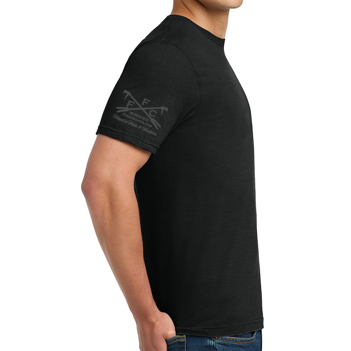 A man wearing a black short-sleeve t-shirt with a dark gray graphic on the left sleeve, shown from a side profile against a white background.