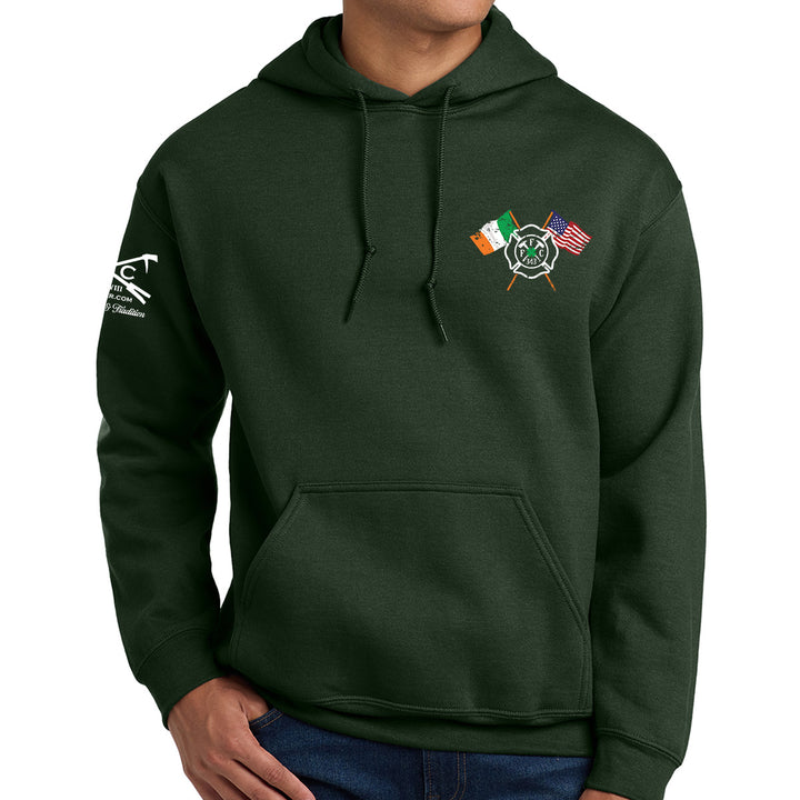 A dark forest green pullover hoodie with a front kangaroo pocket, featuring a small graphic of crossed Irish and American flags with a central emblem on the left chest, and a white graphic on the right sleeve. The hoodie is modeled on a person against a plain white background. #color_forest-green