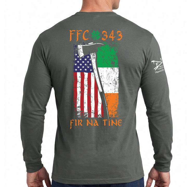 A man wearing a dark gray long-sleeve t-shirt, viewed from the back. The shirt features a large graphic print on the back with an axe, the Irish flag, the US flag, and the text 'FFC  343' and 'FIR NA TINE' in orange. #color_charcoal