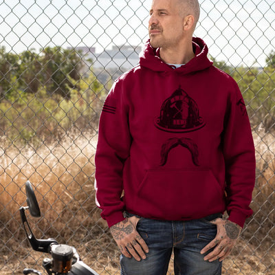 A man wearing a firefighter hoodies shirt with a full front design featuring a firefighter helmet and mustache.