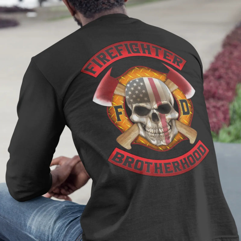 A man wearing a black firefighter long sleeve shirt with a full back design of a skull design with an American flag and crossed axe