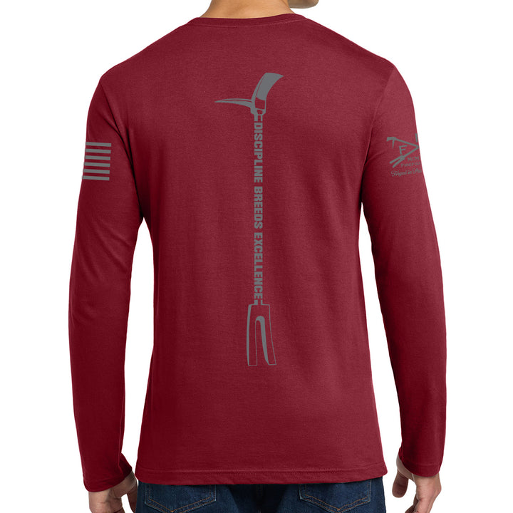 A man wearing a heathered red long-sleeve t-shirt, viewed from the back. The shirt features a large gray graphic of a pickaxe with the vertical text #color_cardinal-red