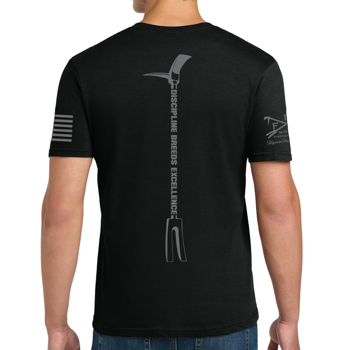 A man wearing a black short-sleeve t-shirt, viewed from the back. The shirt features a large gray graphic of a pitchfork with the words 'DISCIPLINE BREEDS EXCELLENCE' printed vertically down the center back. #color_black