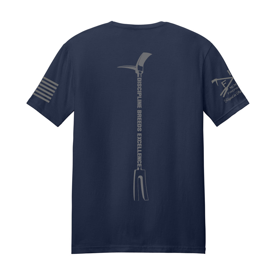 A navy blue short-sleeve t-shirt shown from the back, featuring a large gray vertical graphic of a pickaxe with the text 'discipline breeds EXCELLENT.' and 'PICKAXE' printed vertically, along with gray graphics on both sleeves, on a solid white background. #color_navy