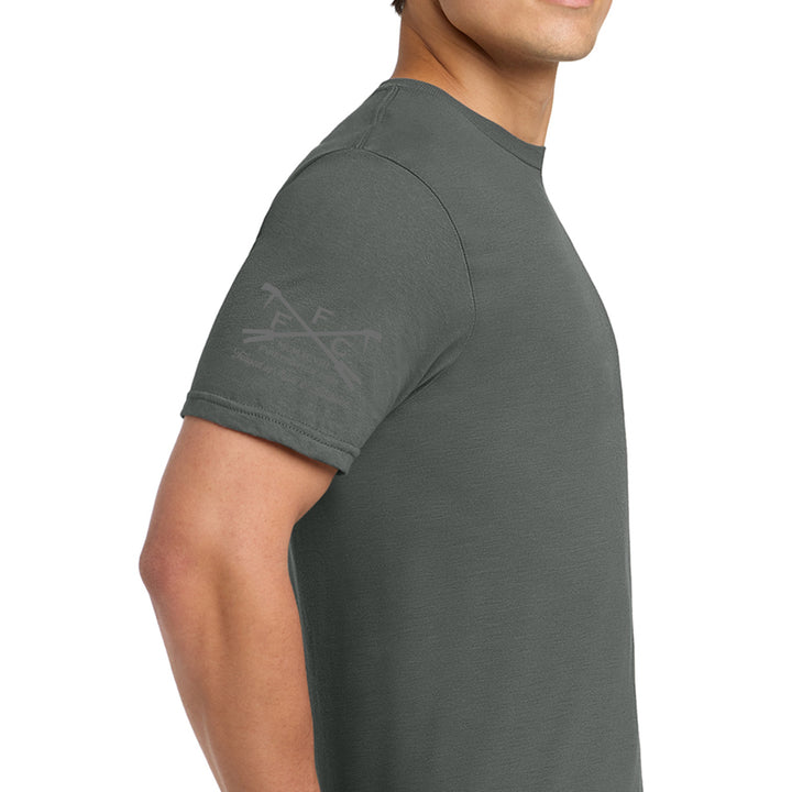 A man wearing a dark gray crewneck t-shirt, shown from a side profile view against a plain white background. The shirt features a subtle, tonal gray graphic on the left sleeve.  #color_charcoal