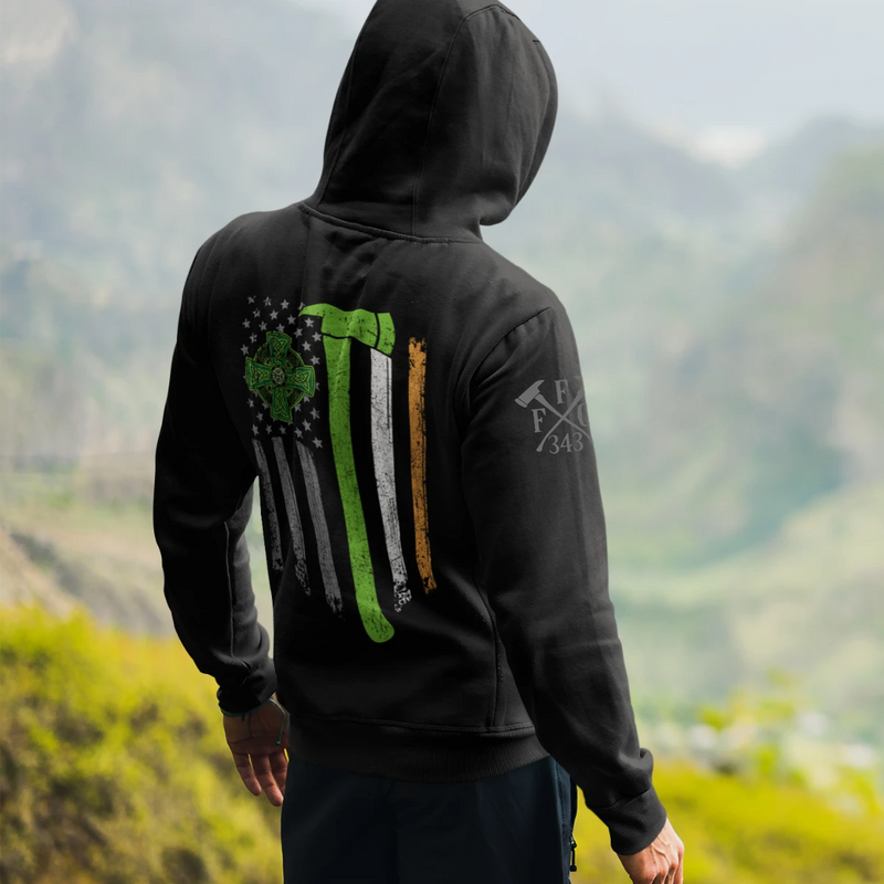 A man wearing a black firefighter hoodies shirt with a full back design featuring a distressed USA flag accented by a green axe-perfect for fire department apparel