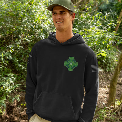 A man wearing a black firefighter hoodies shirt with a full back design featuring a distressed USA flag accented by a green axe-perfect for fire department apparel