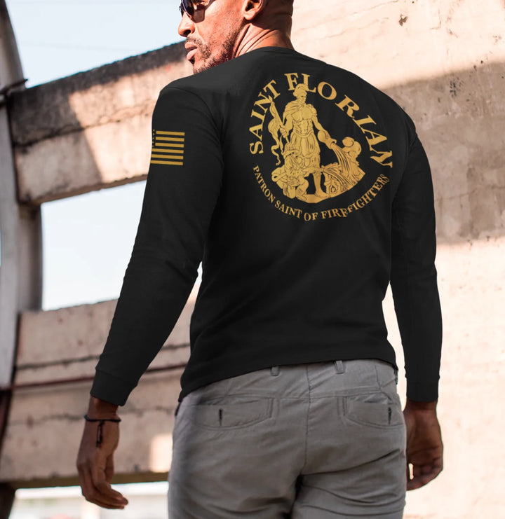 A man wearing a black firefighter long sleeve shirt with a full back design featuring the Saint Florian Patron Saint of Firefighters