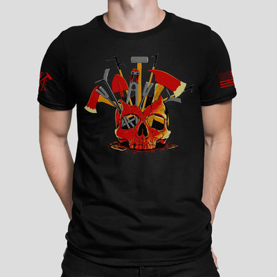 A man wearing a black firefighter T-shirt showing the full-front design of a skull filled with firefighter tools