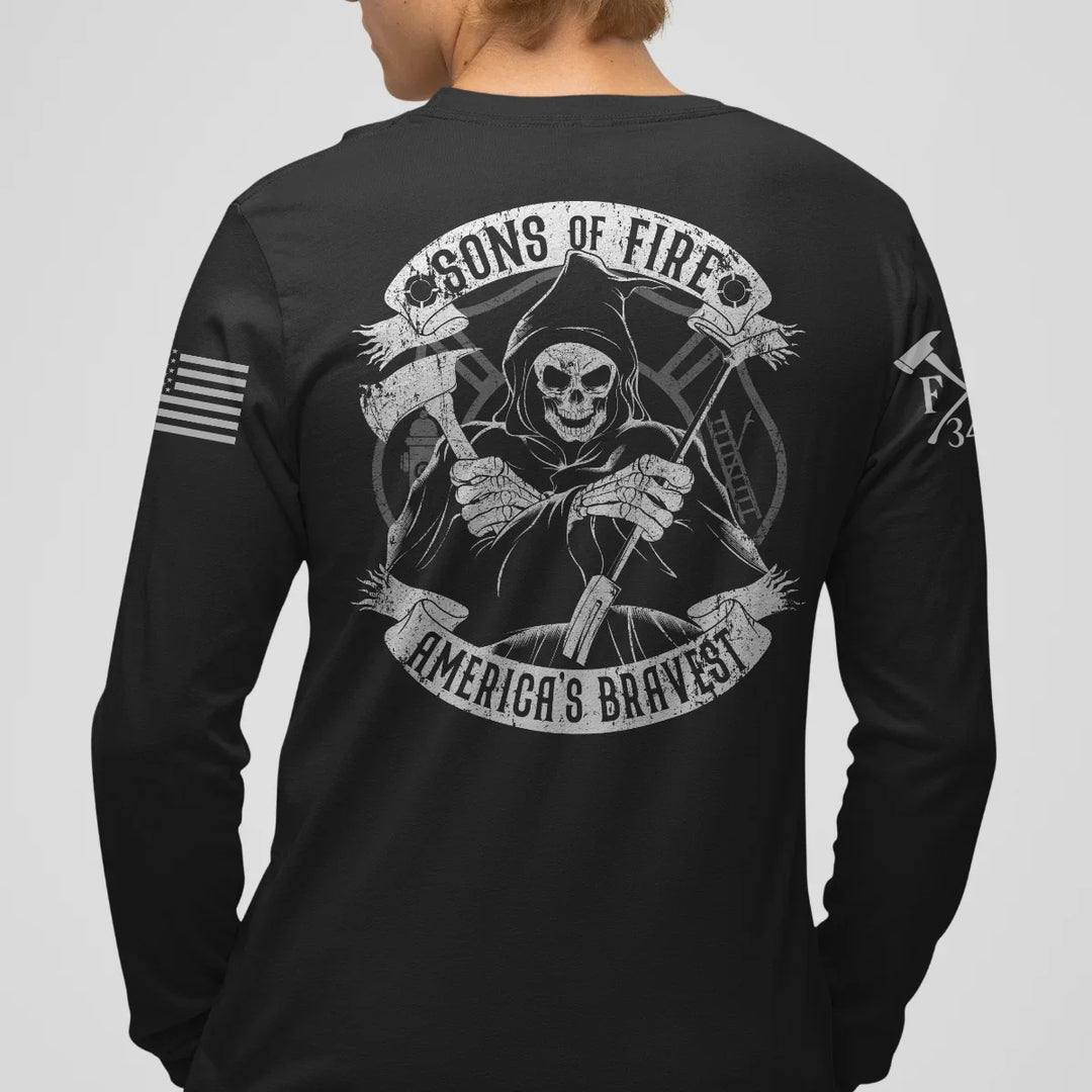 A man wearing a firefighter graphic long sleeve shirt featuring a skeleton holding a hooligan bar and an axe with text Sons Of Fire Americas Bravest