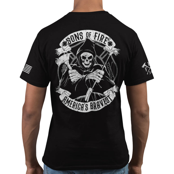 A man wearing a firefighter graphic t-shirt featuring a skeleton holding a hooligan bar and an axe with text Sons Of Fire Americas Bravest