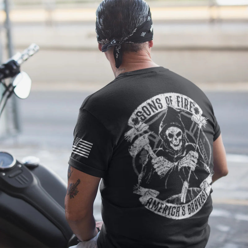 A man wearing a firefighter graphic t-shirt featuring a skeleton holding a hooligan bar and an axe with text Sons Of Fire Americas Bravest