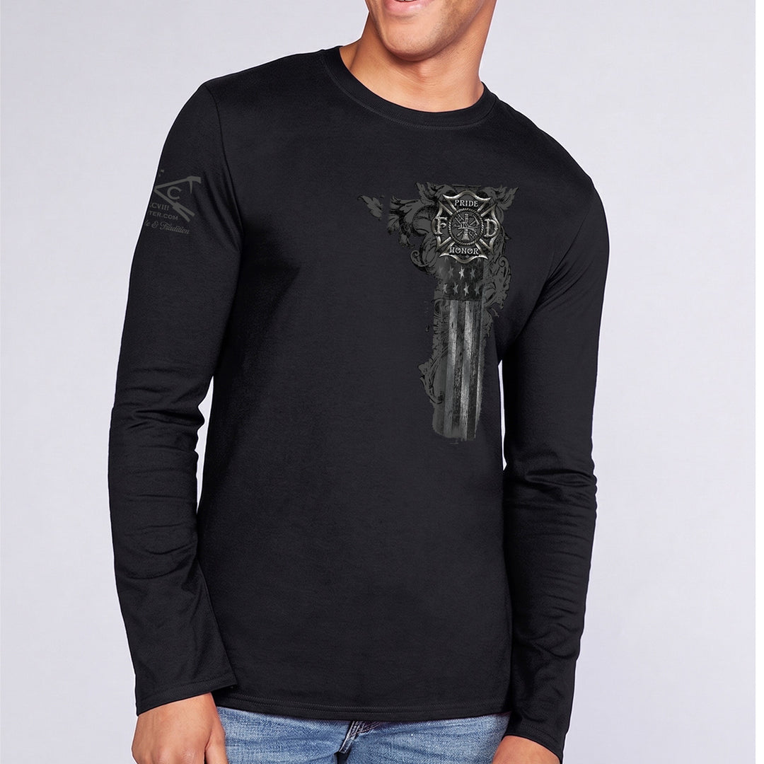 A man wearing a black long-sleeve t-shirt with a distressed, dark gray American flag graphic on the front and a logo on the left sleeve, paired with blue jeans against a light gray background.  #color_black
