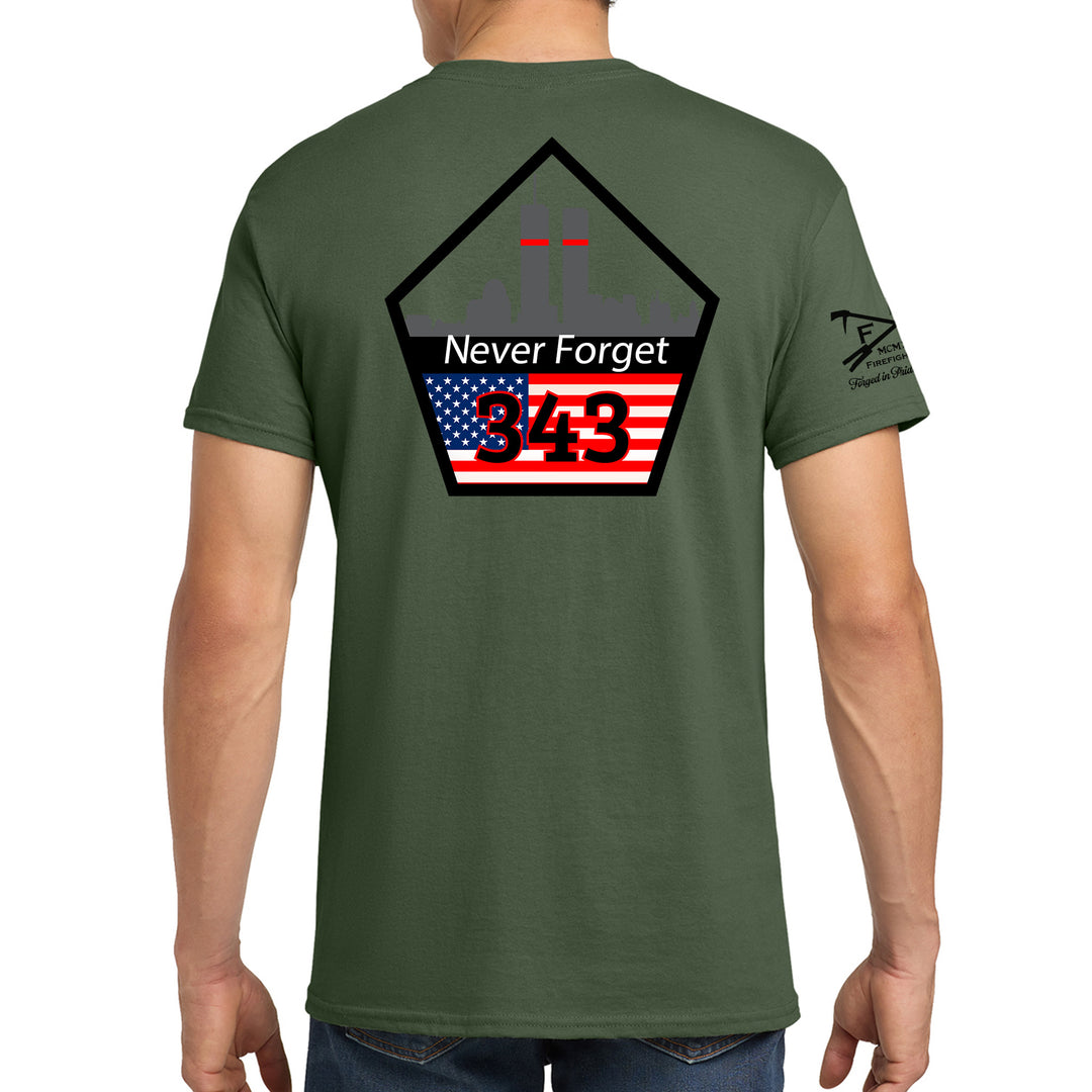 A man wearing an olive green t-shirt, viewed from the back. The shirt features a large graphic on the back with a black pentagonal outline, the words 'Never Forget' in white, the number '943' in red over an American flag design, and a small black graphic on the left sleeve. #color_military-green